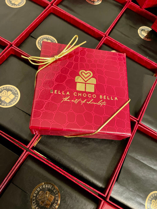 Red crocodile-finish 4-piece chocolate gift box with gold ribbon, a corporate gift from Bella Choco Bella, Hoboken