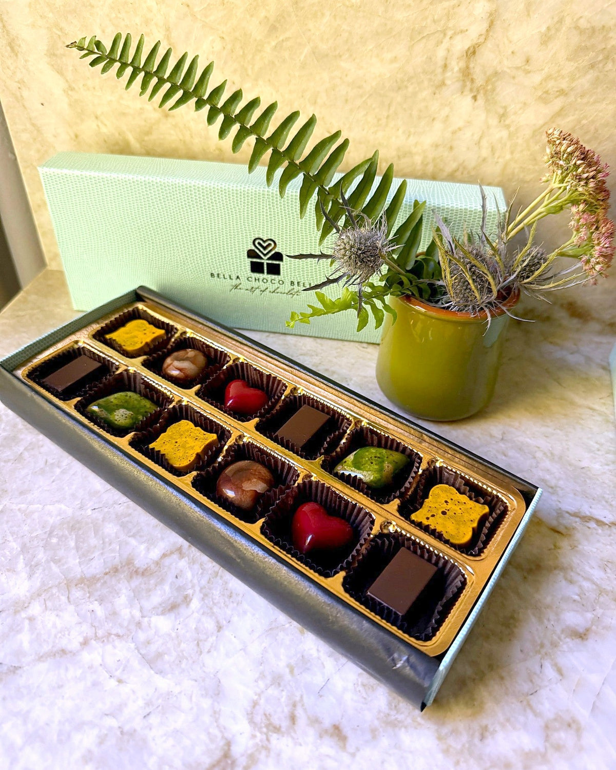 Tiffany Blue 12-piece box open with hand-painted bonbons on a gold tray